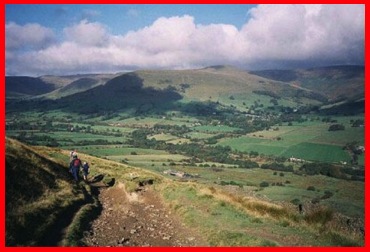 Walking from Hollins Cross towards Edale with Grindsbrook Clough and the Kinder Plateau beyond.