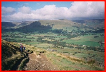 Walking from Hollins Cross towards Edale with Grindsbrook Clough and the Kinder Plateau beyond.