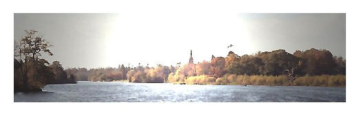 View of the lake, trees and top of Clumber Chapel .