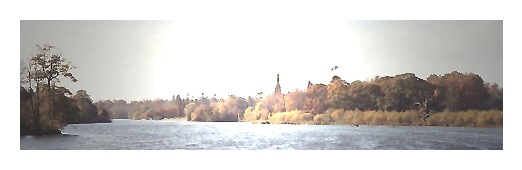 View of the lake, trees and top of Clumber Chapel .