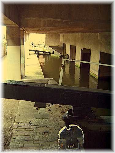 The Birmingham and Fazeley Canal, complete with locks, under one of the buildings near the centre of Birmingham.