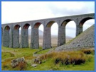 The Ribblehead Viaduct with Ingleborough behind .
